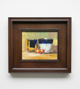 A framed still life painting featuring ceramic vessels and red cherries, housed in a dark brown wooden frame and mounted on a light gray wall.