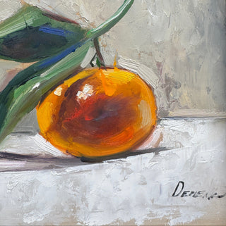 A framed still life painting of an orange with green leaves, featuring thick impasto brushstrokes and a textured neutral background, enclosed in a dark wood frame.